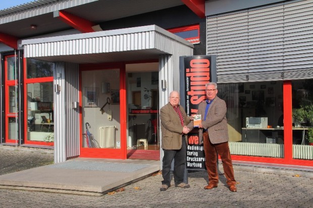 Hans Weber (hw-studio weber) übergibt Lothar Ludwig (Mitautor des Buches) den Ratgeber Das andere Leben im November 2013